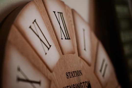 a close up of a wooden clock with roman numerals