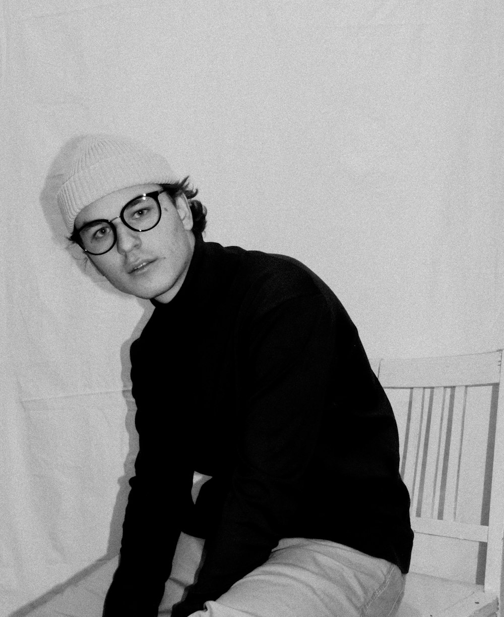 Una foto in bianco e nero di un uomo che porta gli occhiali
