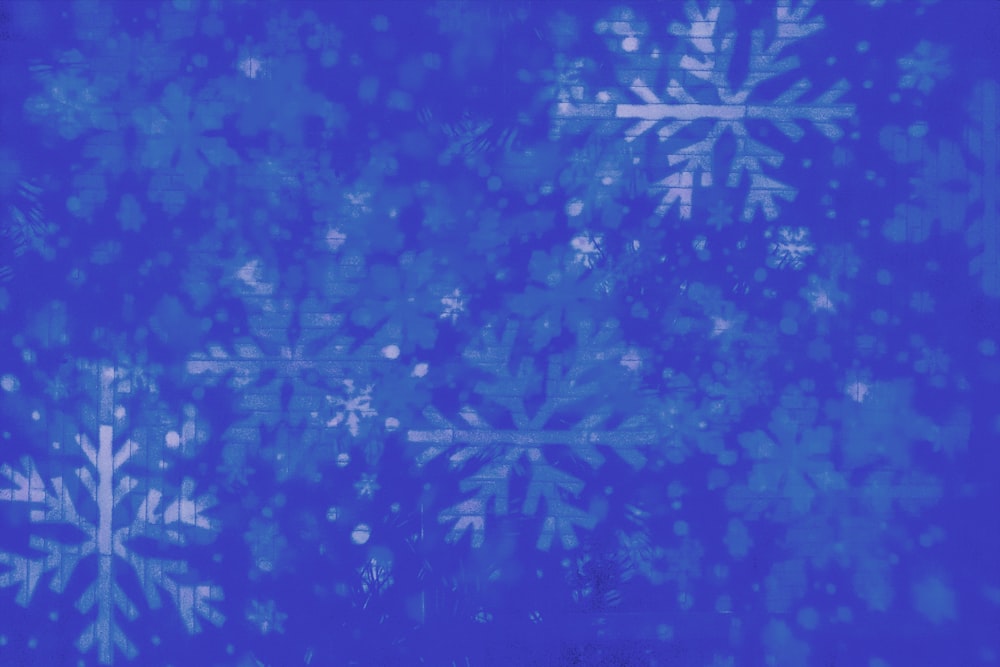 uno sfondo blu con fiocchi di neve bianchi su di esso