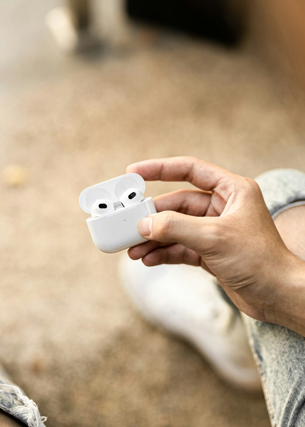 a person holding an apple airpods in their hand