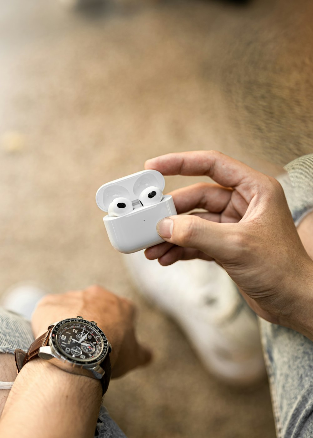a person holding an airpods in their hand