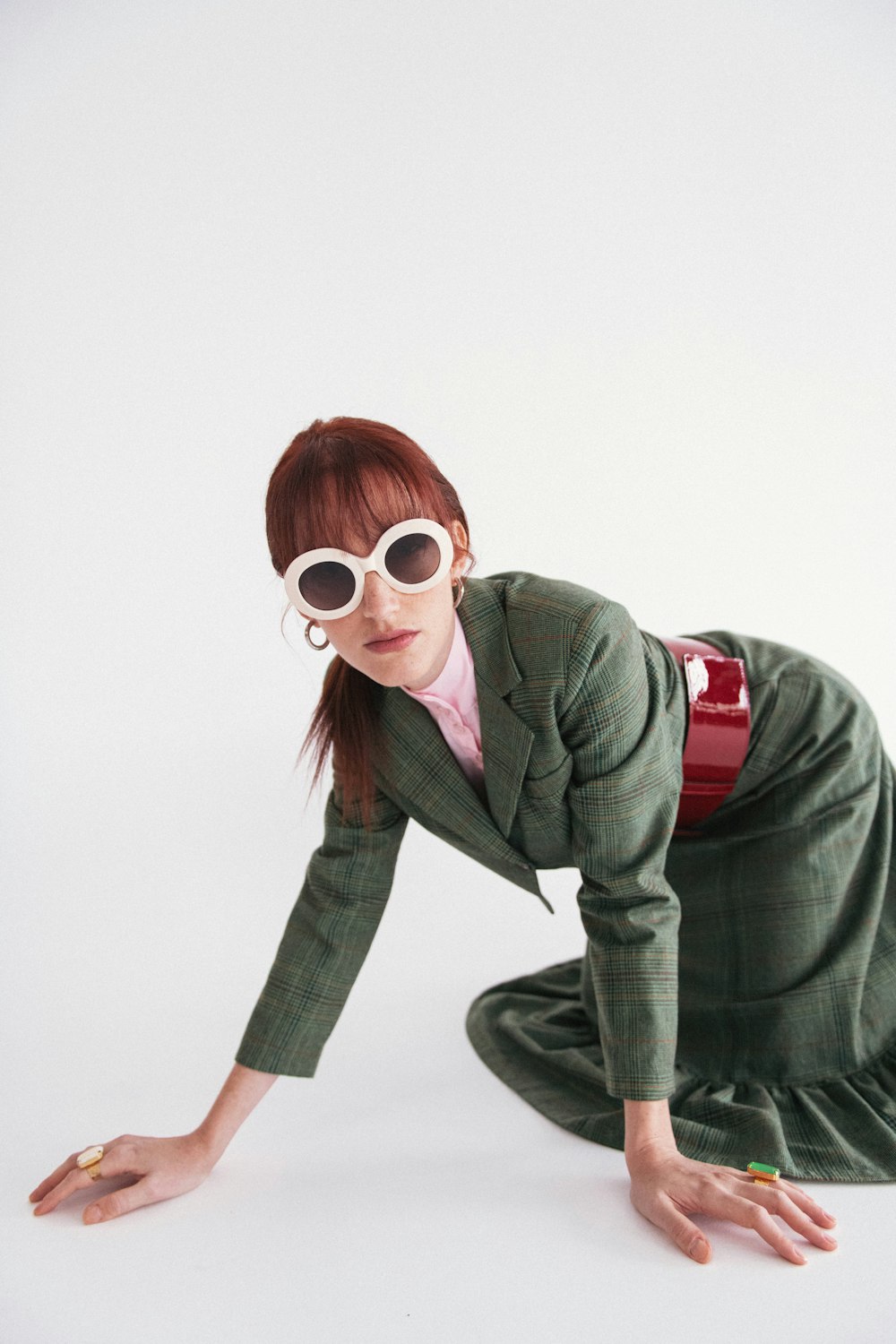 a woman in a green suit and white sunglasses