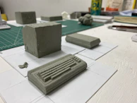 An array of miniature scale models arranged neatly on a dark grey industrial-style table.