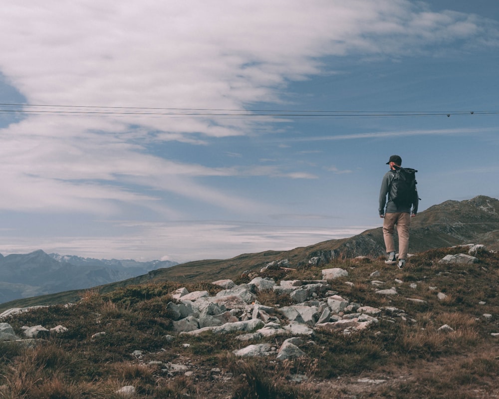 a man standing on top of a rocky hill