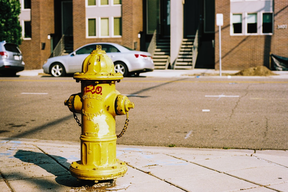 a yellow fire hydrant sitting on the side of a road