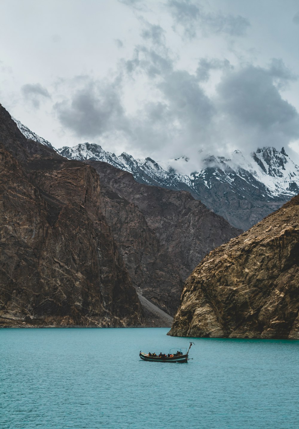 a boat floating on top of a lake surrounded by mountains