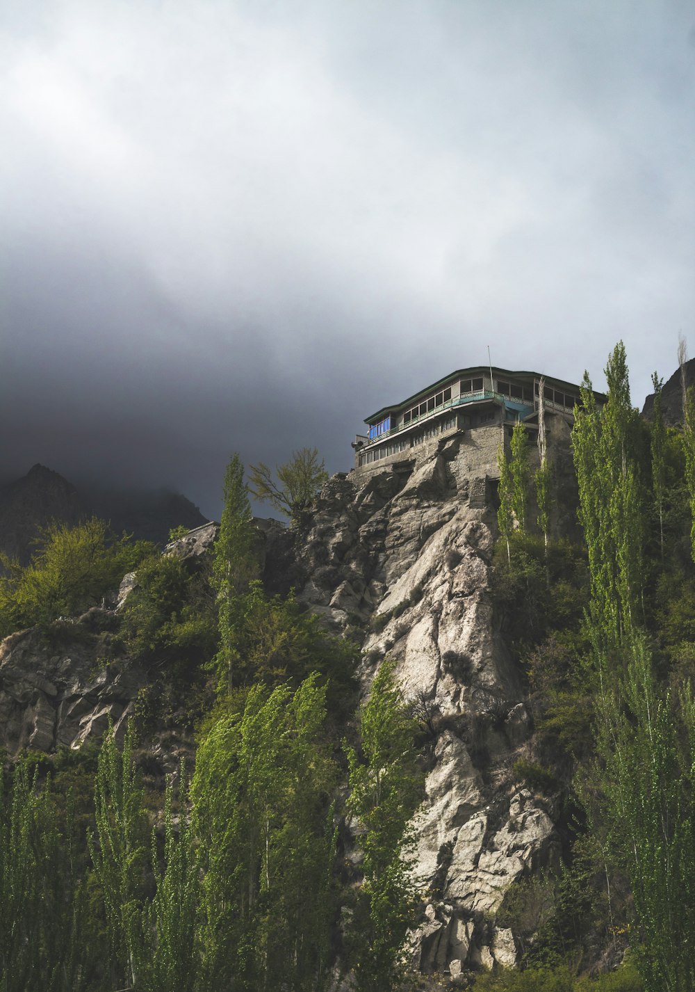 Une maison au sommet d’une montagne entourée d’arbres