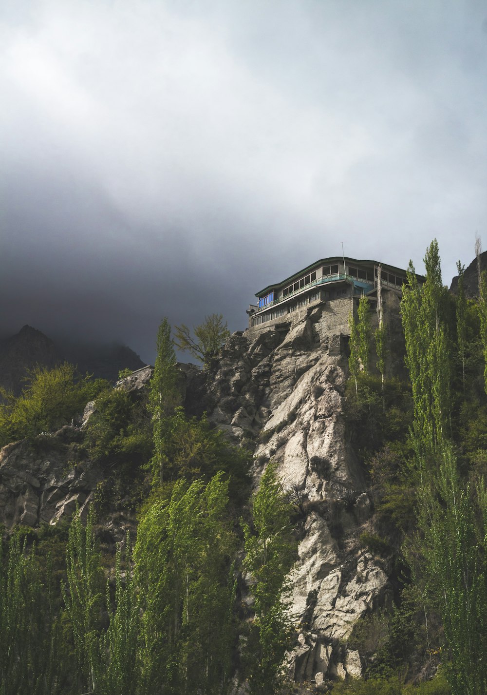 a house on top of a mountain surrounded by trees