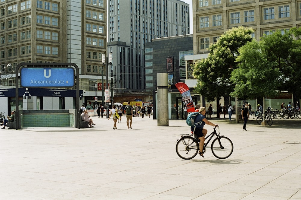 a man riding a bike down a street next to tall buildings