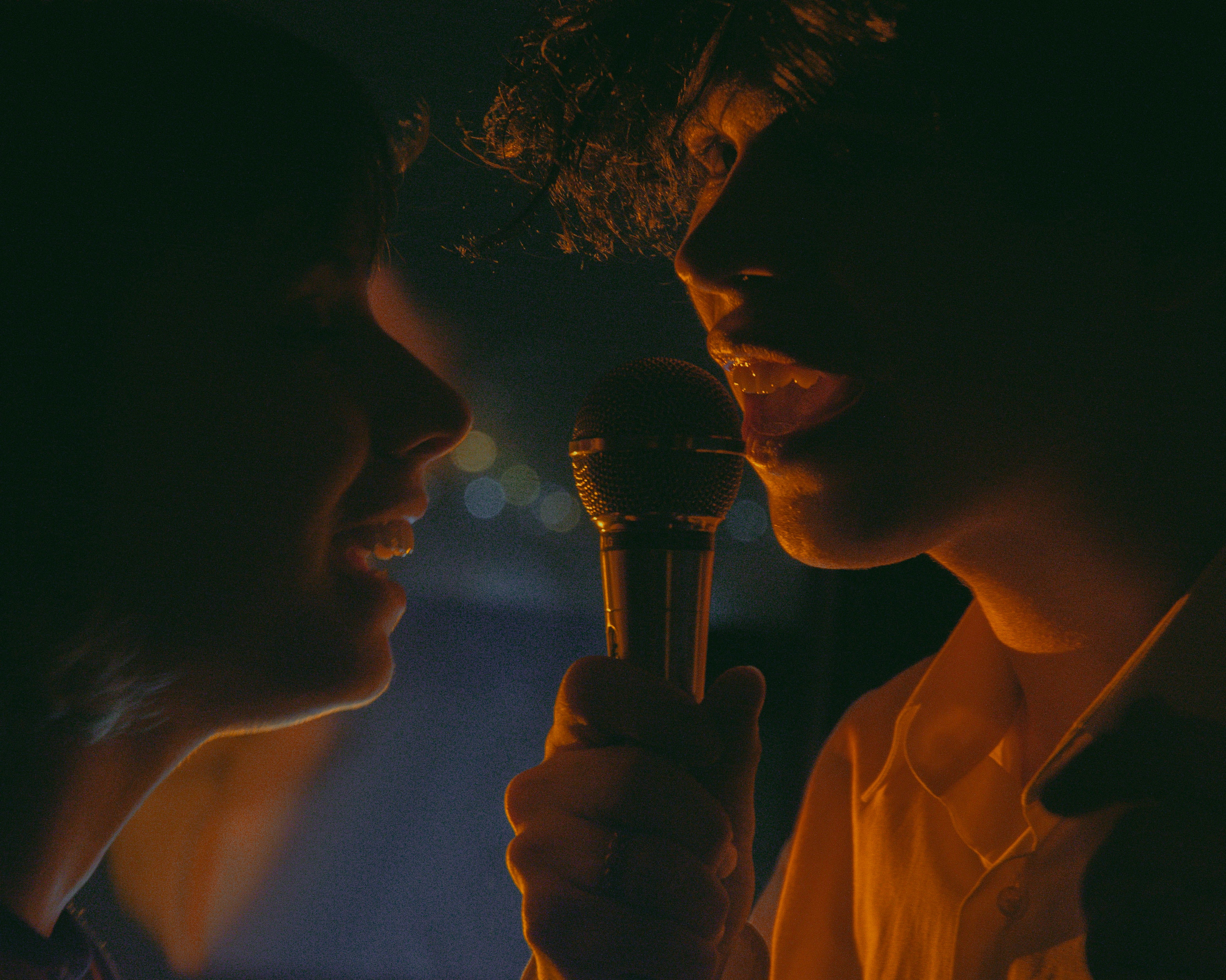 a woman holding a microphone in front of a man, 