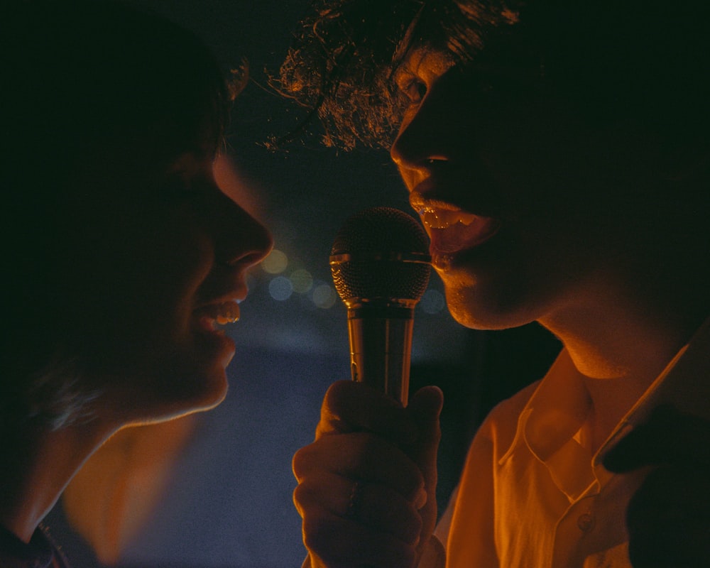 a woman holding a microphone in front of a man