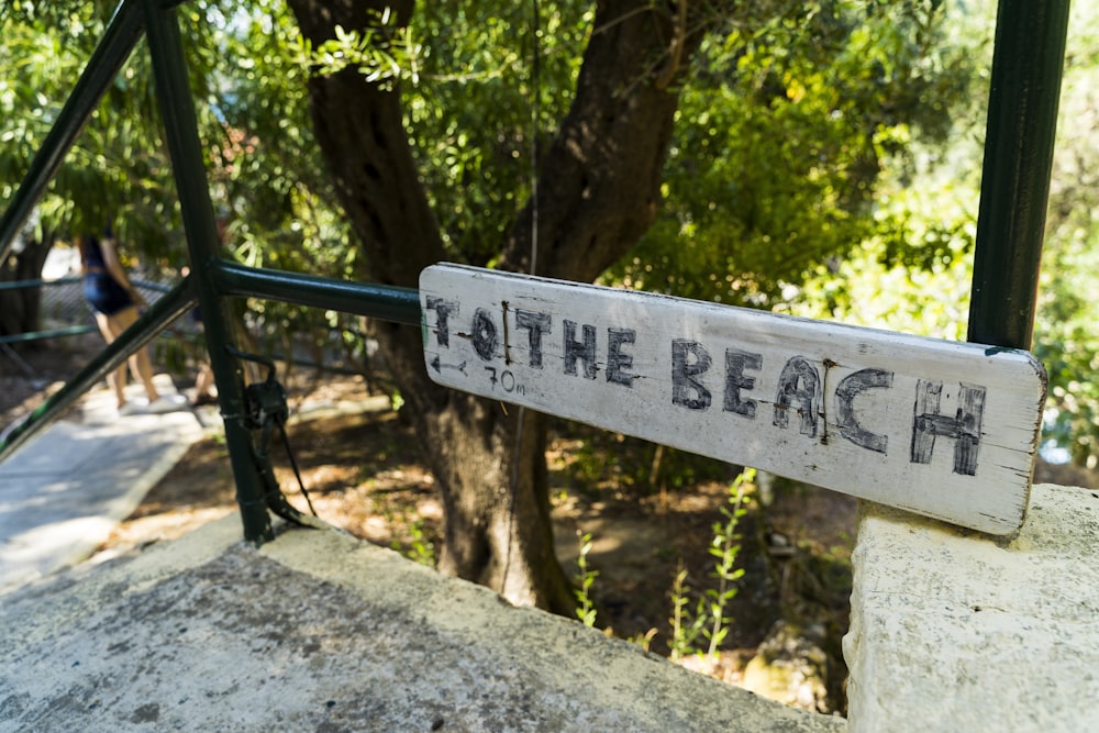 ein Schild, auf dem am Strand steht
