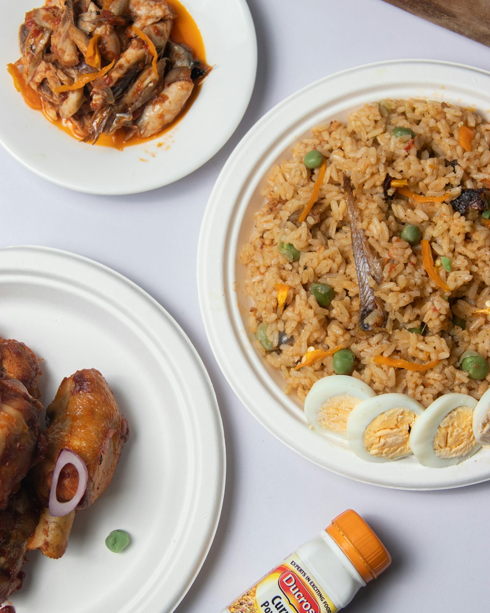 a table topped with plates of food and a bowl of rice