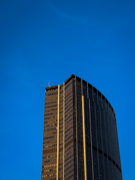 A gleaming commercial highrise with sunlight reflecting off spotless windows.