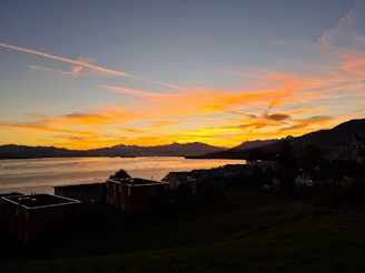 A serene landscape of Barcelona’s coastline at sunset, with vibrant colors reflecting on the water.