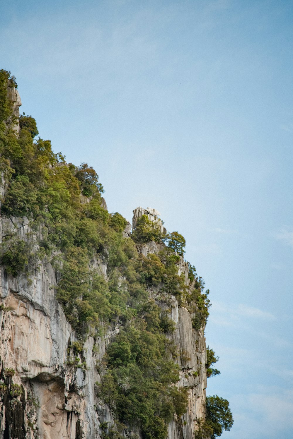 a boat is on the water near a cliff