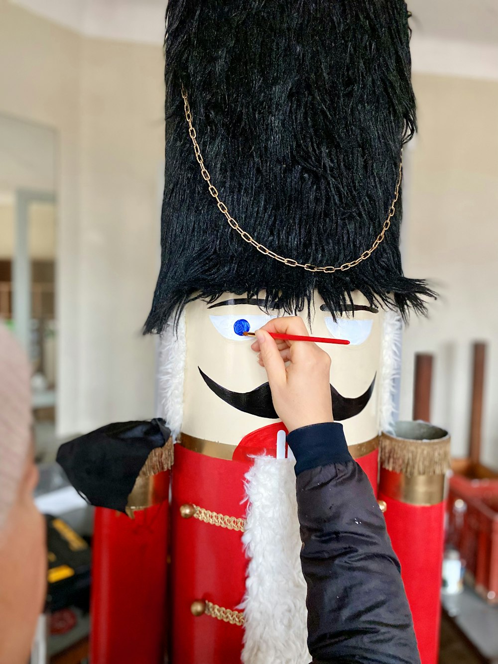 a person painting a nutcracker with a brush