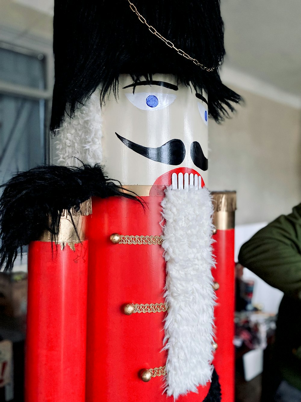a wooden nutcracker with a black hat and a red jacket