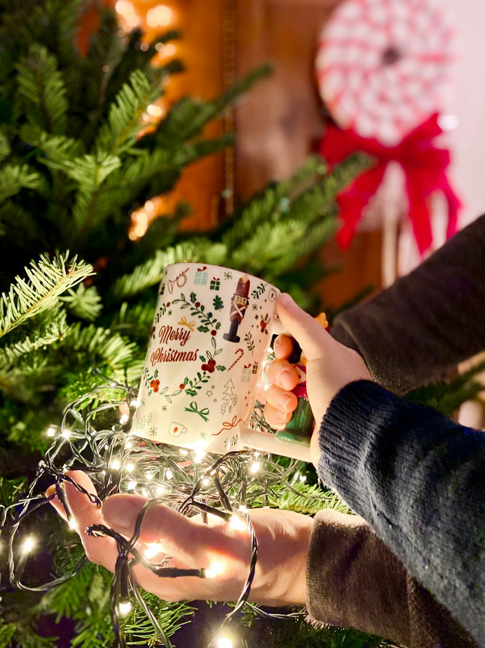 a person holding a book in front of a christmas tree