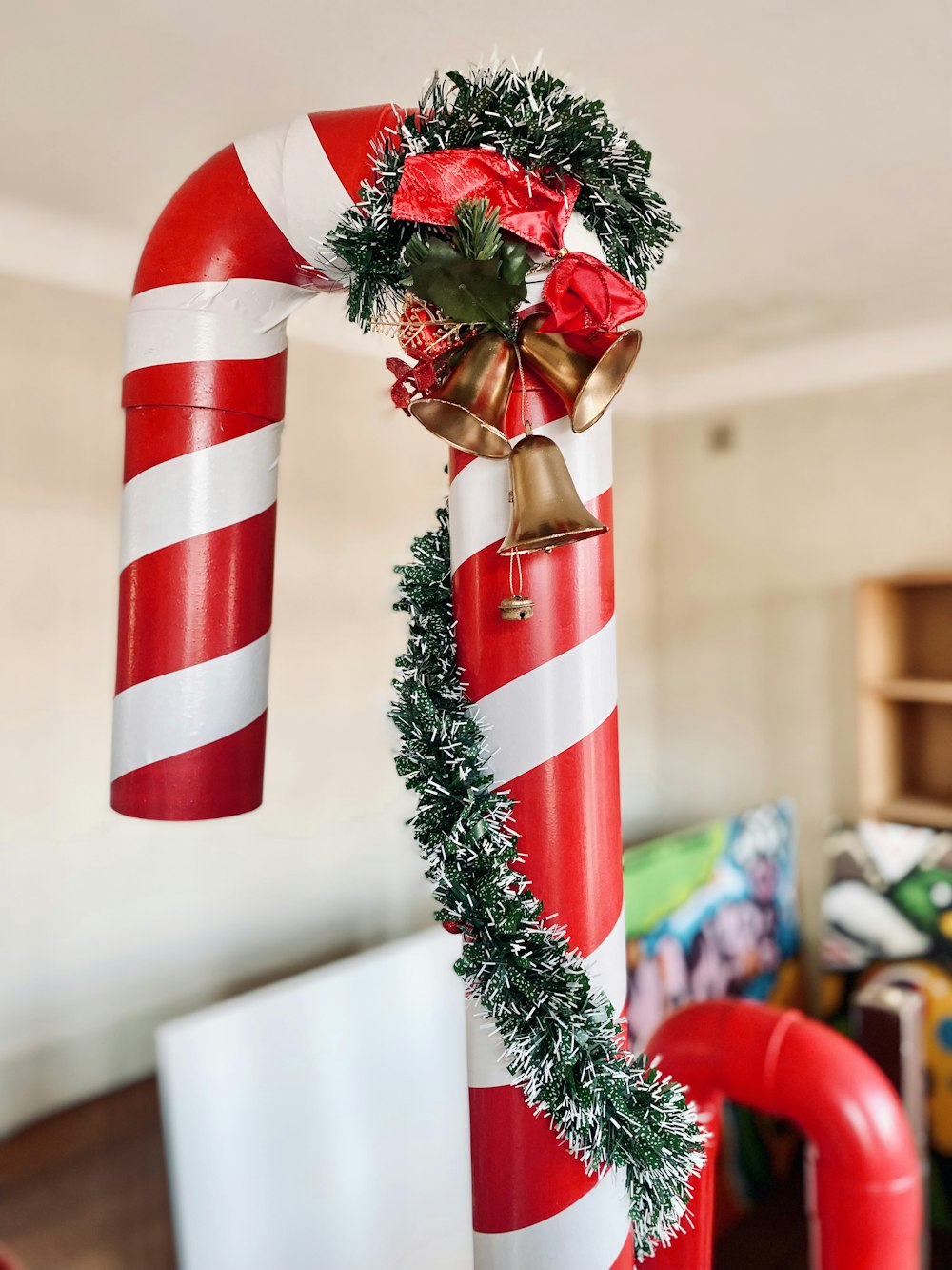 a red and white candy cane decorated with a wreath