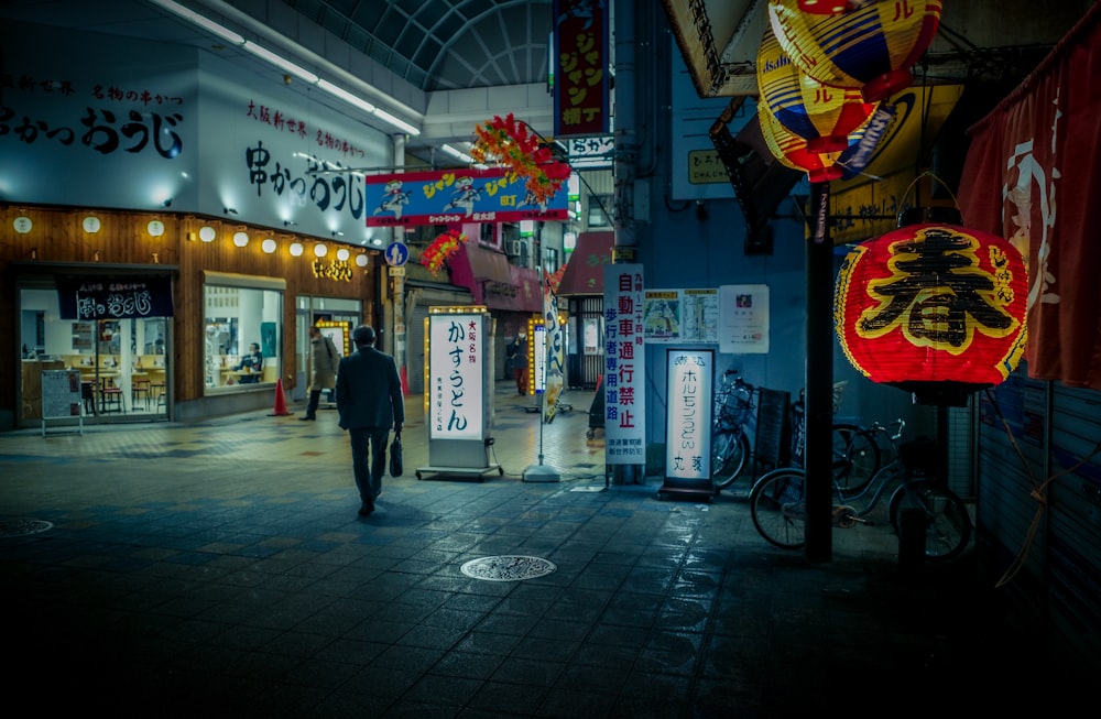 a man walking down a street next to a store