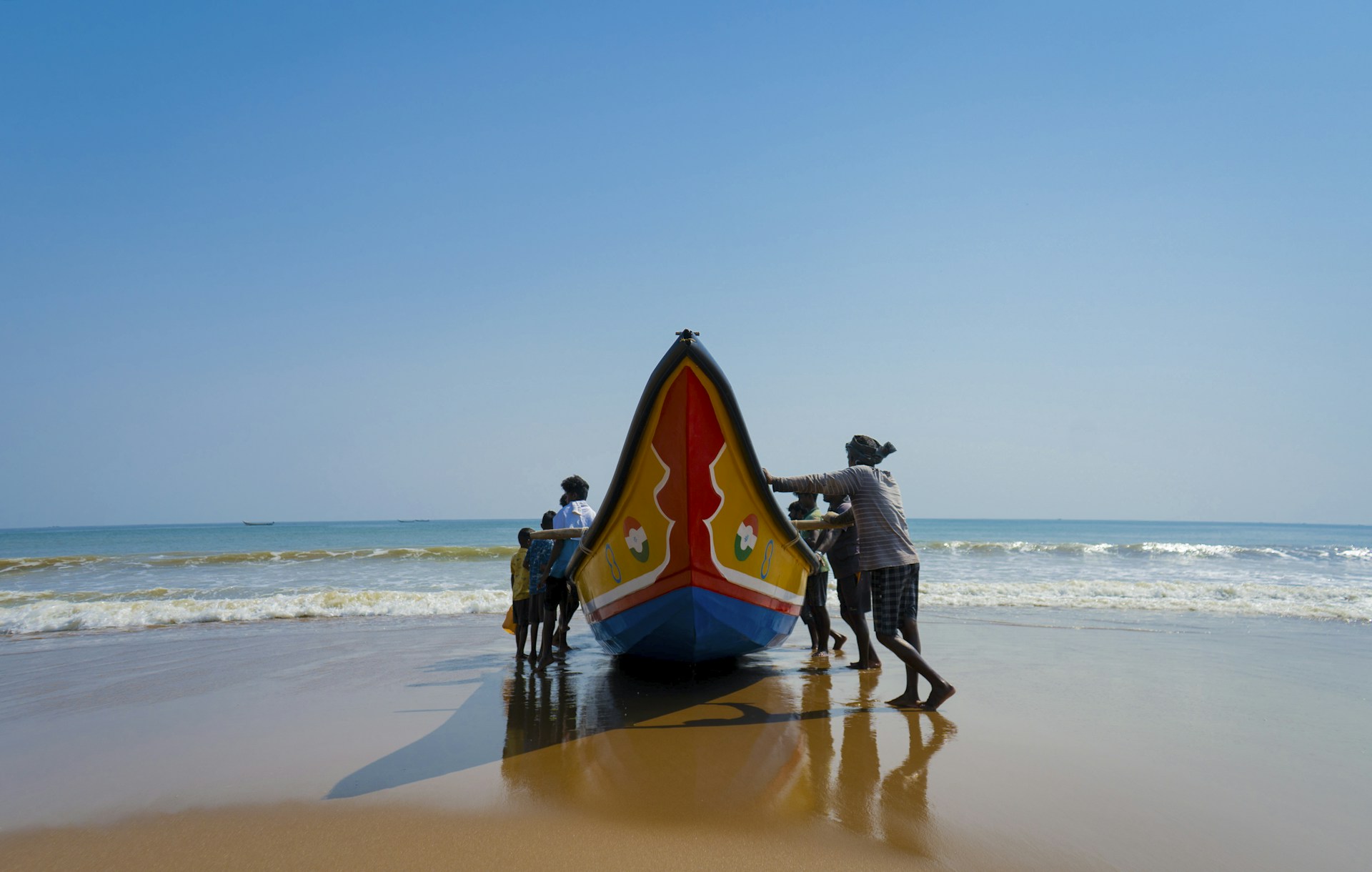 a group of people standing next to a boat on a beach