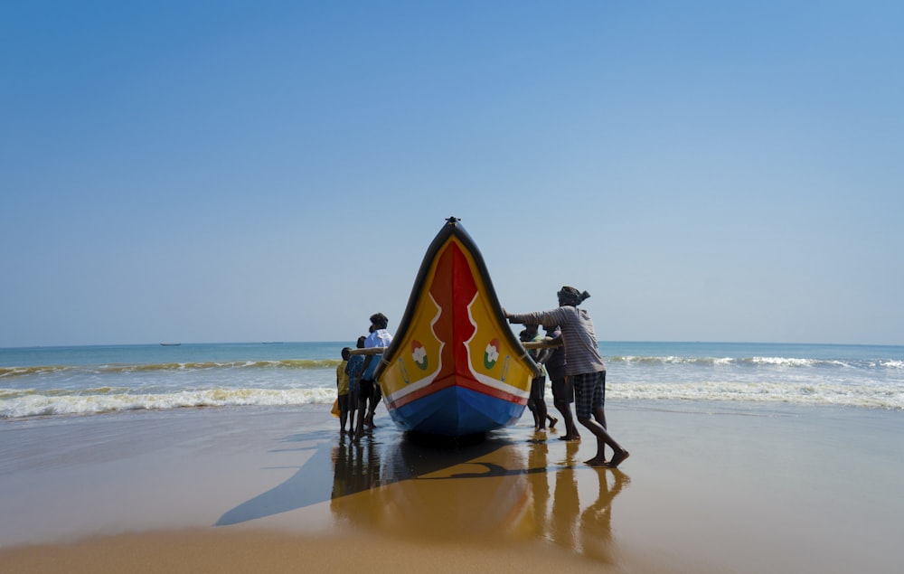 a group of people standing next to a boat on a beach