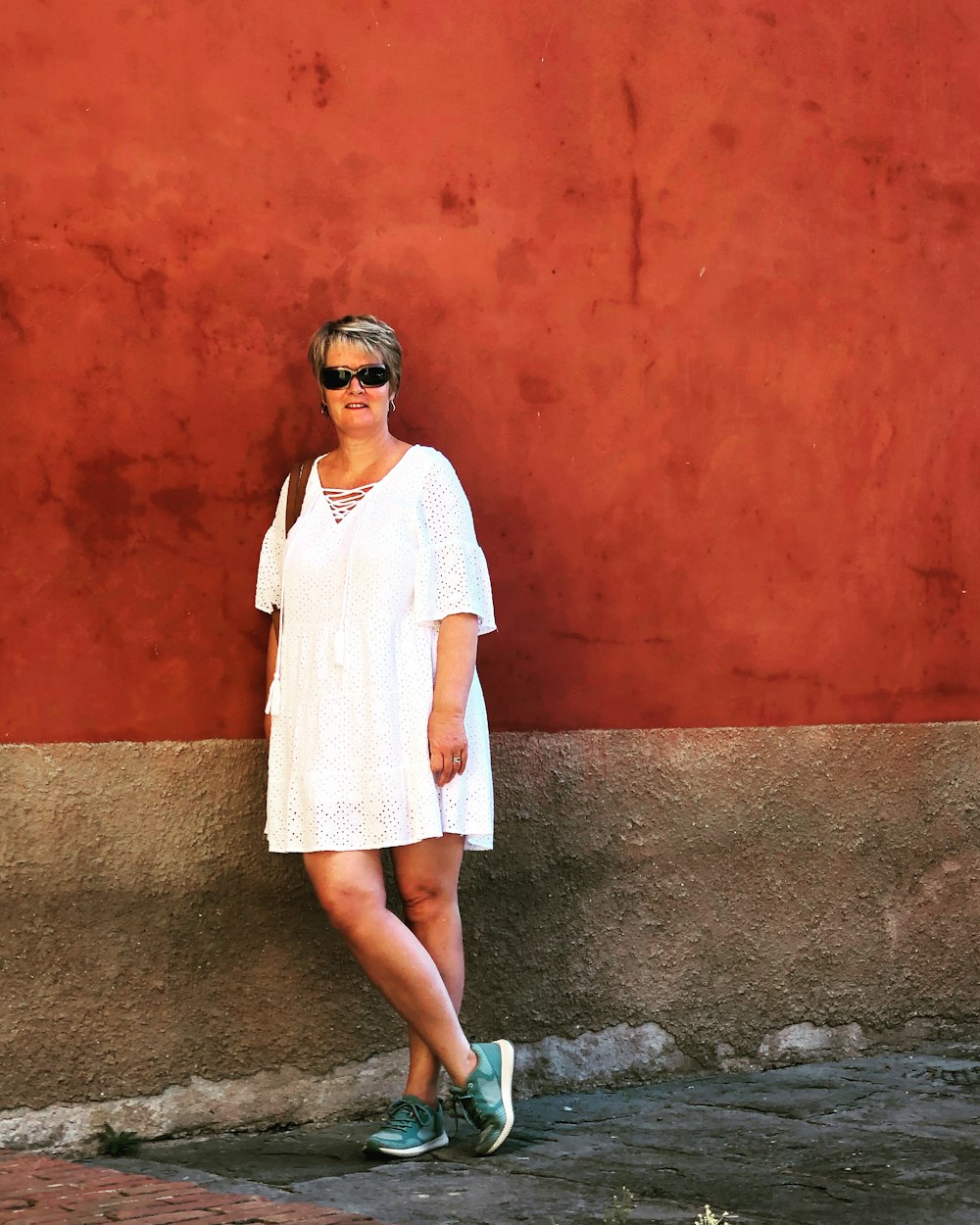 a woman standing in front of a red wall