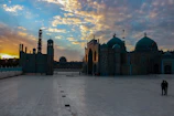 A peaceful mosque courtyard bathed in soft golden light at sunset.