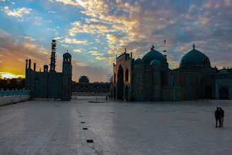 Islamic geometric patterns softly framing a serene mosque courtyard at sunset.