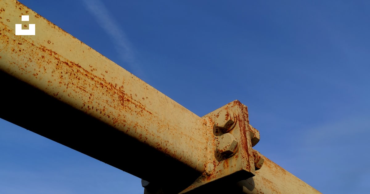 A rusted metal rail with a blue sky in the background photo – Free ...