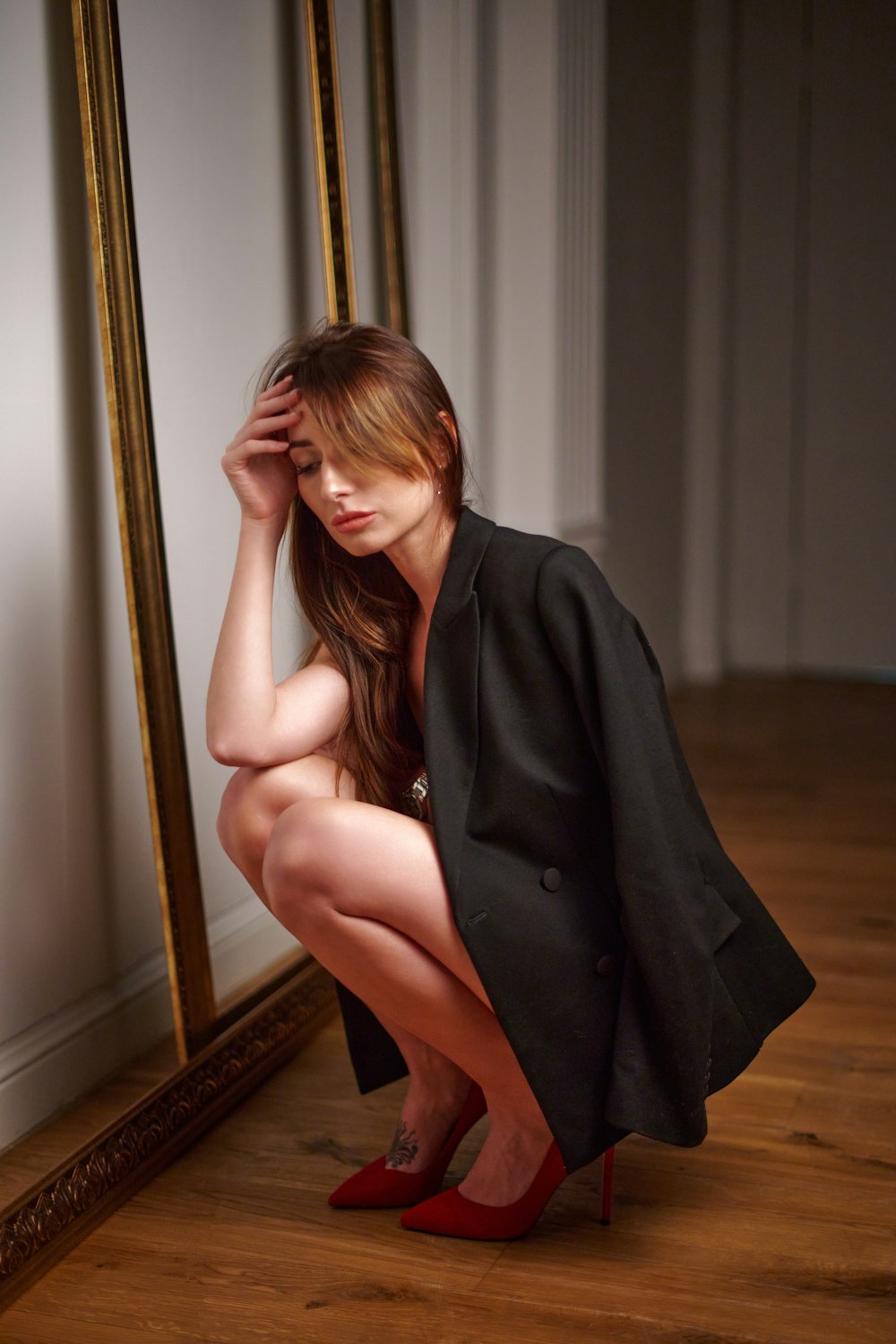 a woman kneeling down in front of a mirror