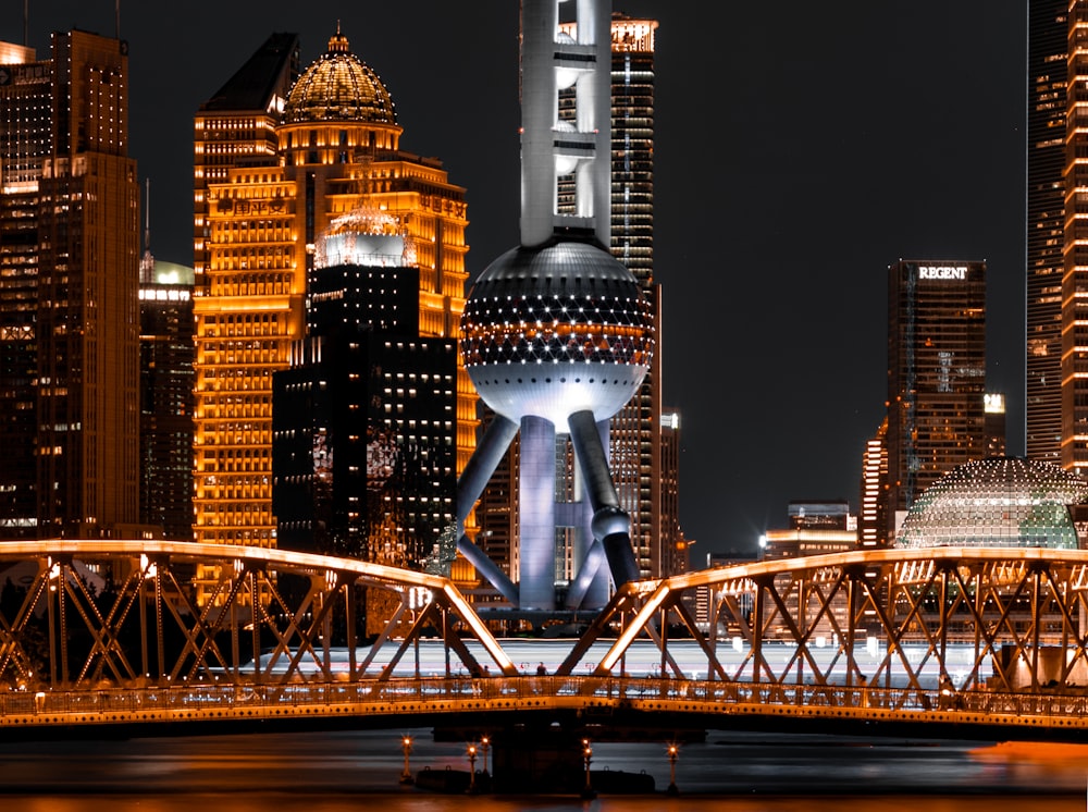 a city skyline at night with a bridge and lights