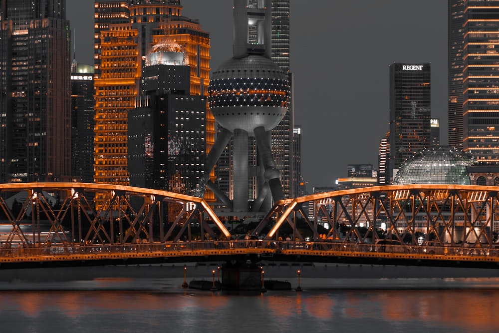 a bridge over a body of water with a city in the background