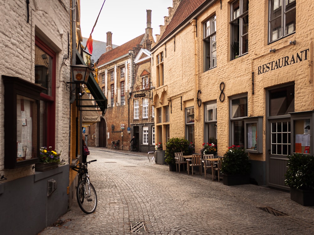 a cobblestone street lined with buildings and tables