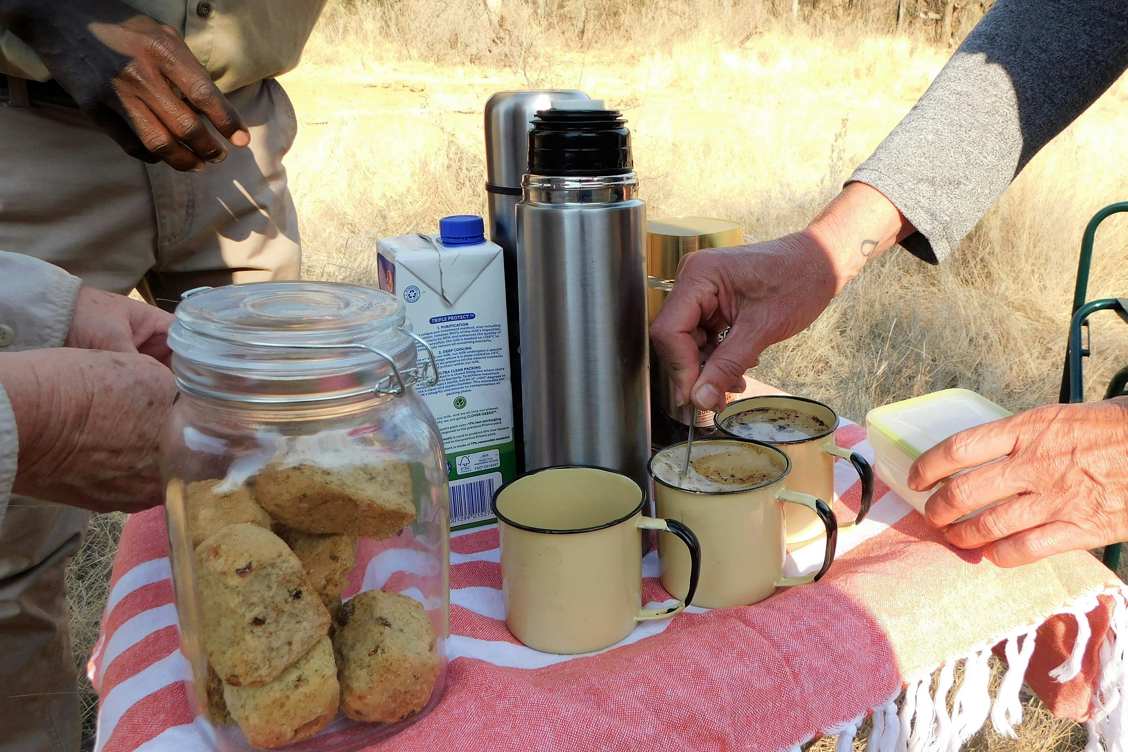a table topped with two mugs of coffee and cookies