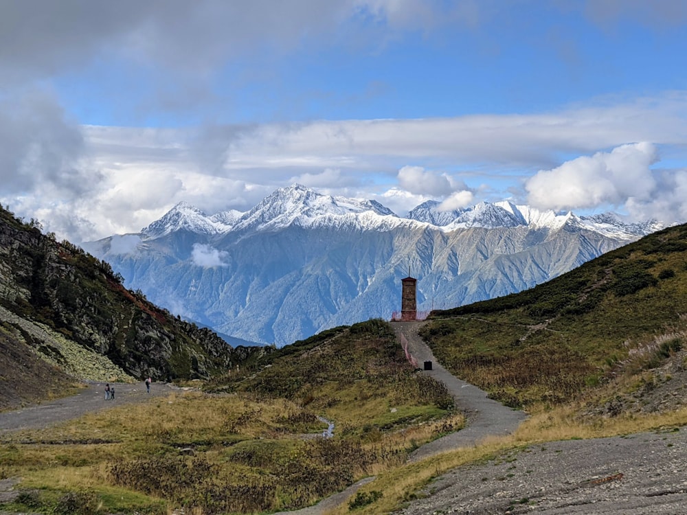 a view of a mountain range with a clock tower in the foreground