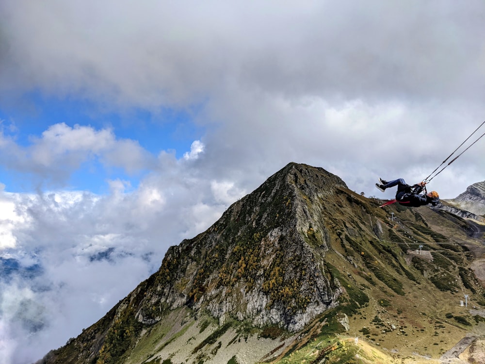 a person on a rope on top of a mountain