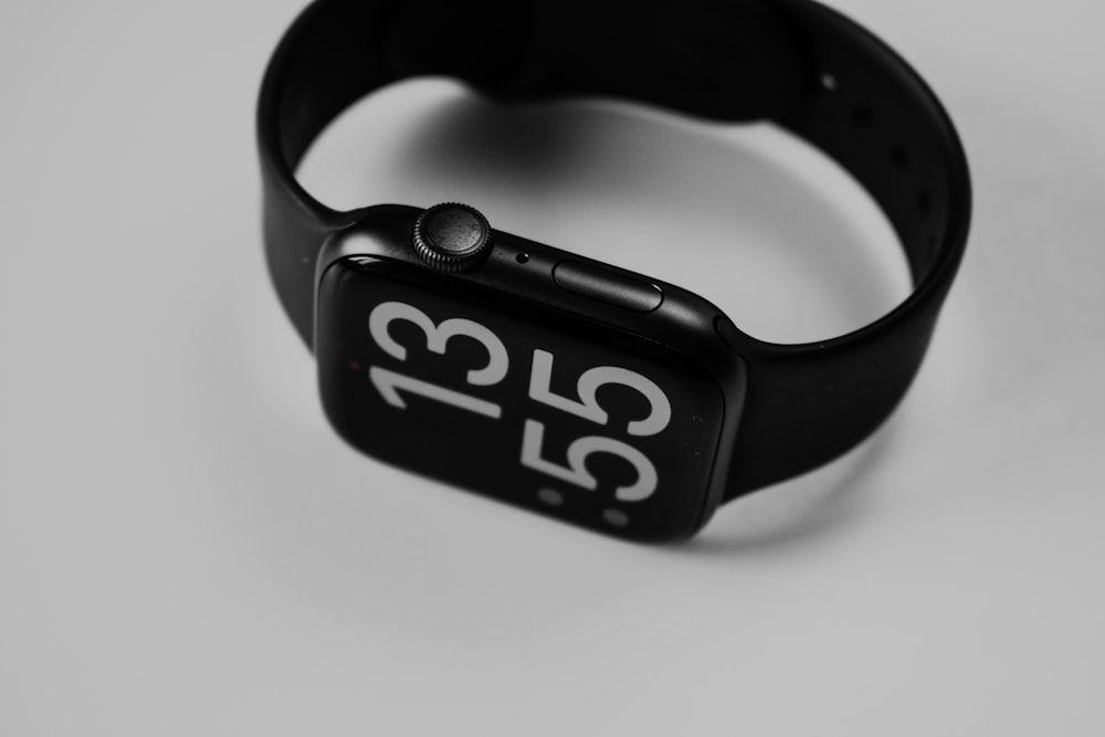 um relógio de maçã com uma faixa preta e números brancos