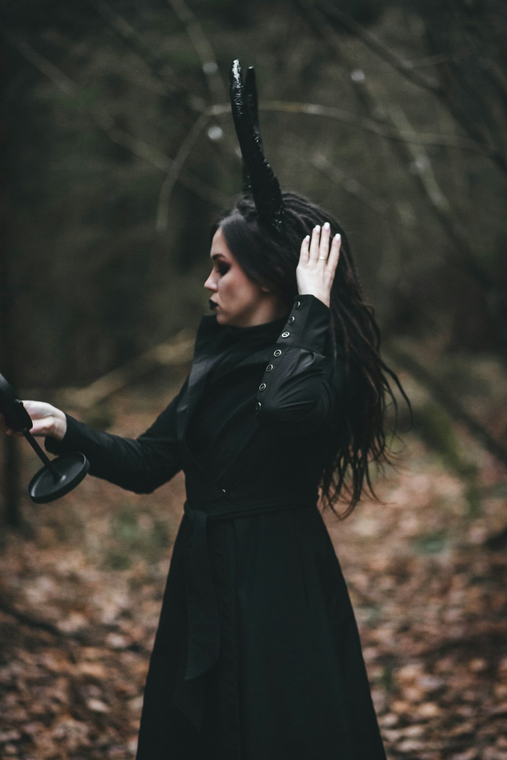 a woman in a black dress holding a black umbrella