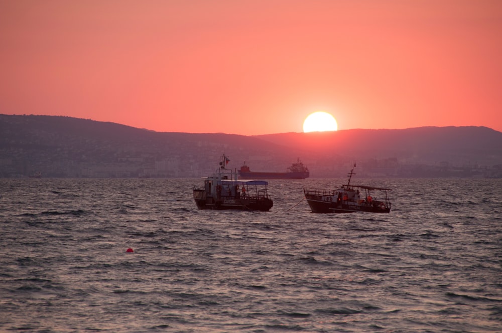 a couple of boats floating on top of a large body of water