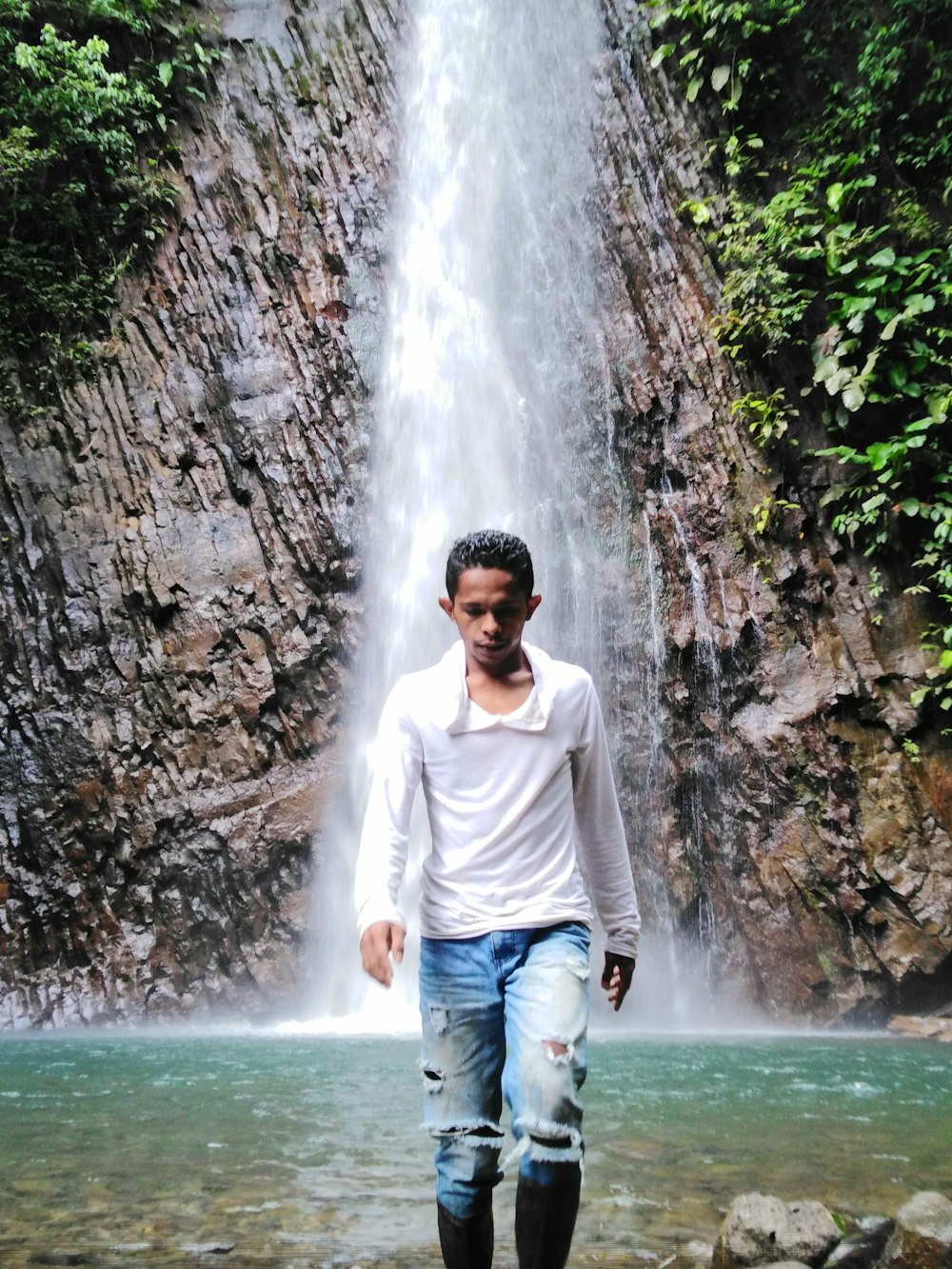 a man standing in front of a waterfall