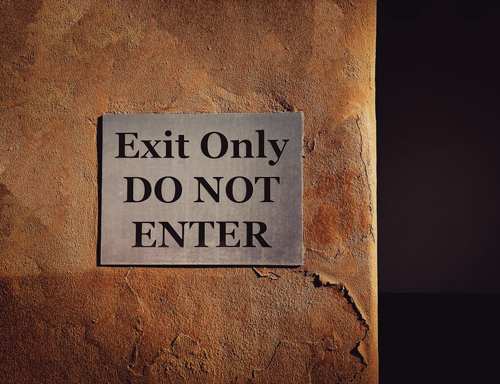 a sign on a wall that says exit only do not enter