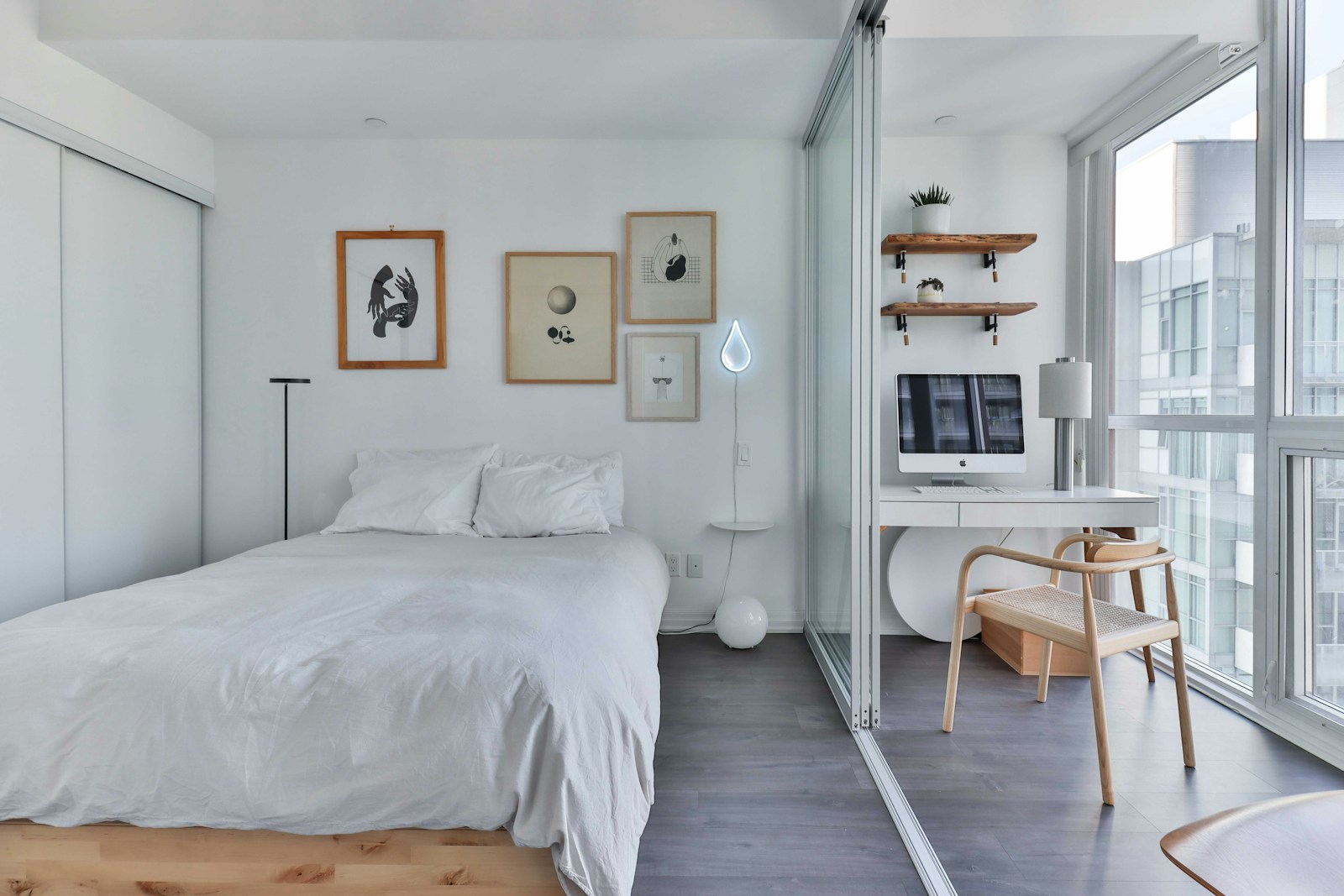 mini gallery wall above bed in modern apartment bedroom