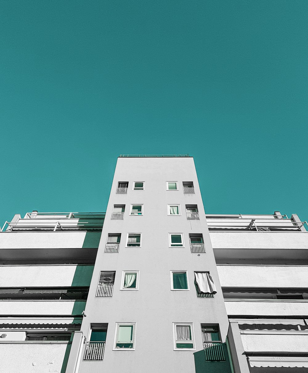 a tall white building with balconies and windows