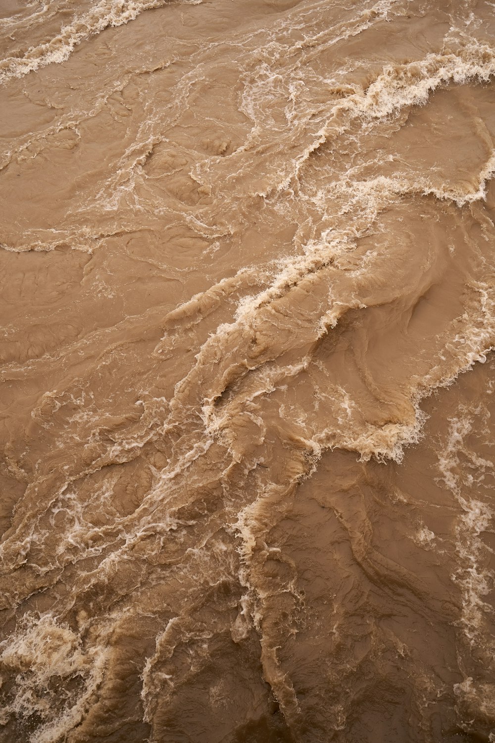 a large body of brown water with waves