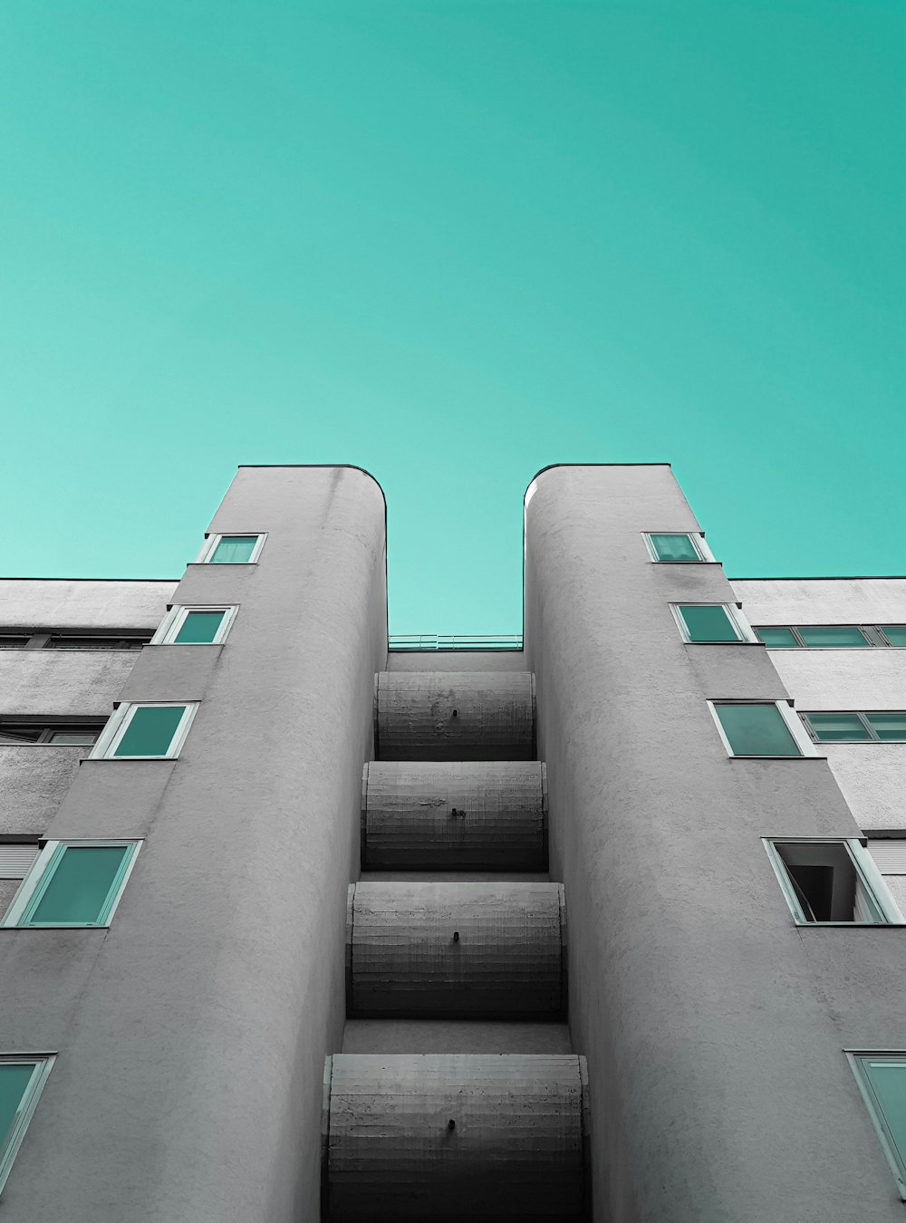 a tall building with windows and a sky background