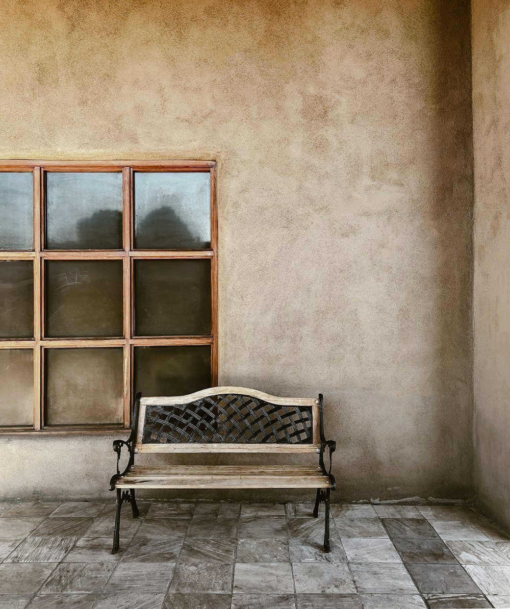 a wooden bench sitting in front of a window