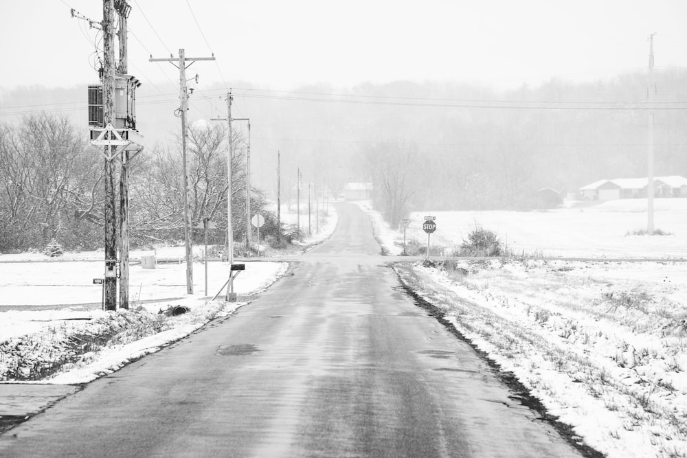 a black and white photo of a snow covered road