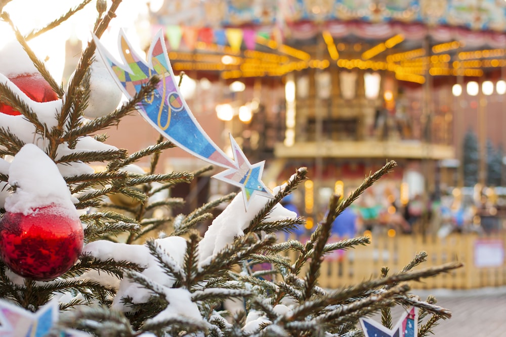 a christmas tree with a merry go round in the background